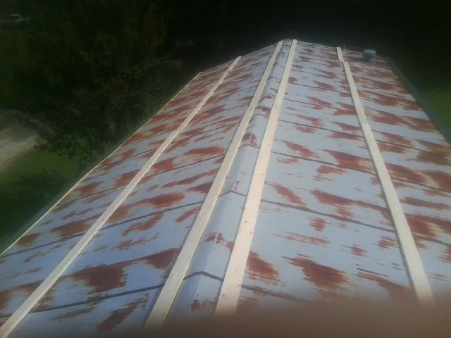 Rusted metal roof panels with new wood purlins before replacement — Storm Damage Roof Repair in Big Rapids by Roofing Brothers
