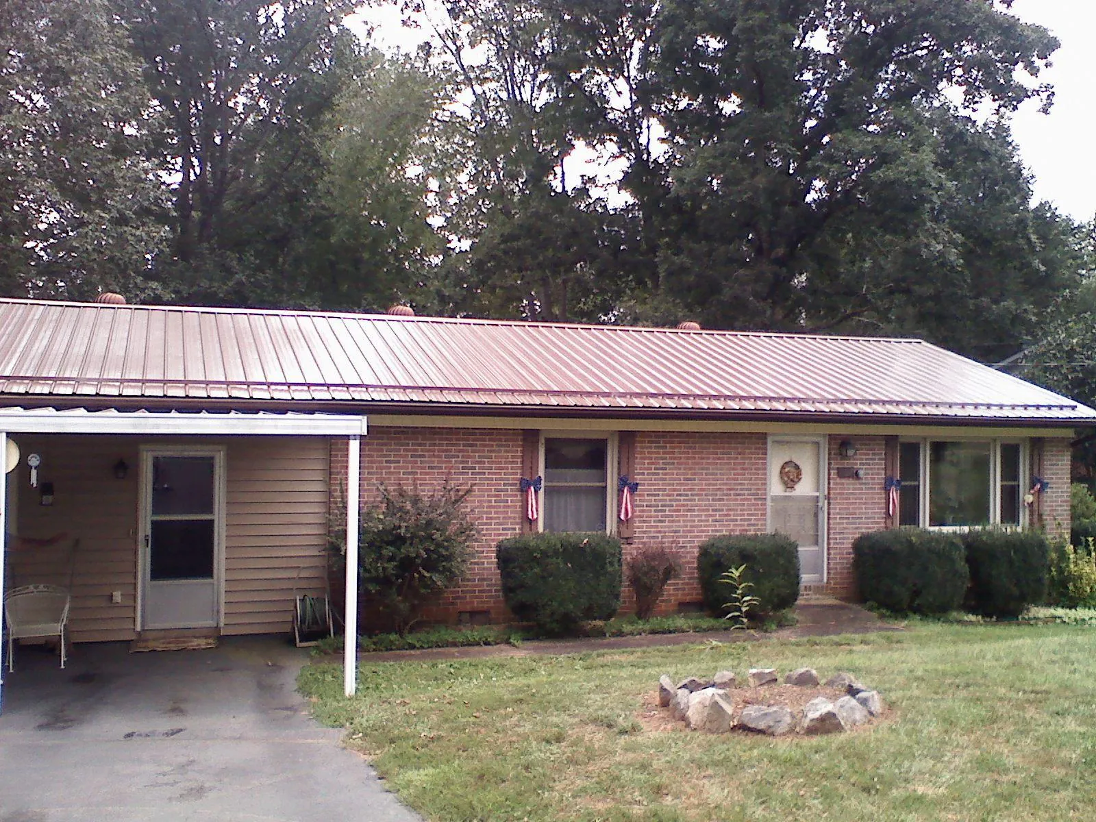 Bronze metal roof and carport on a brick ranch home — Roof Repair work by our crew in Big Rapids